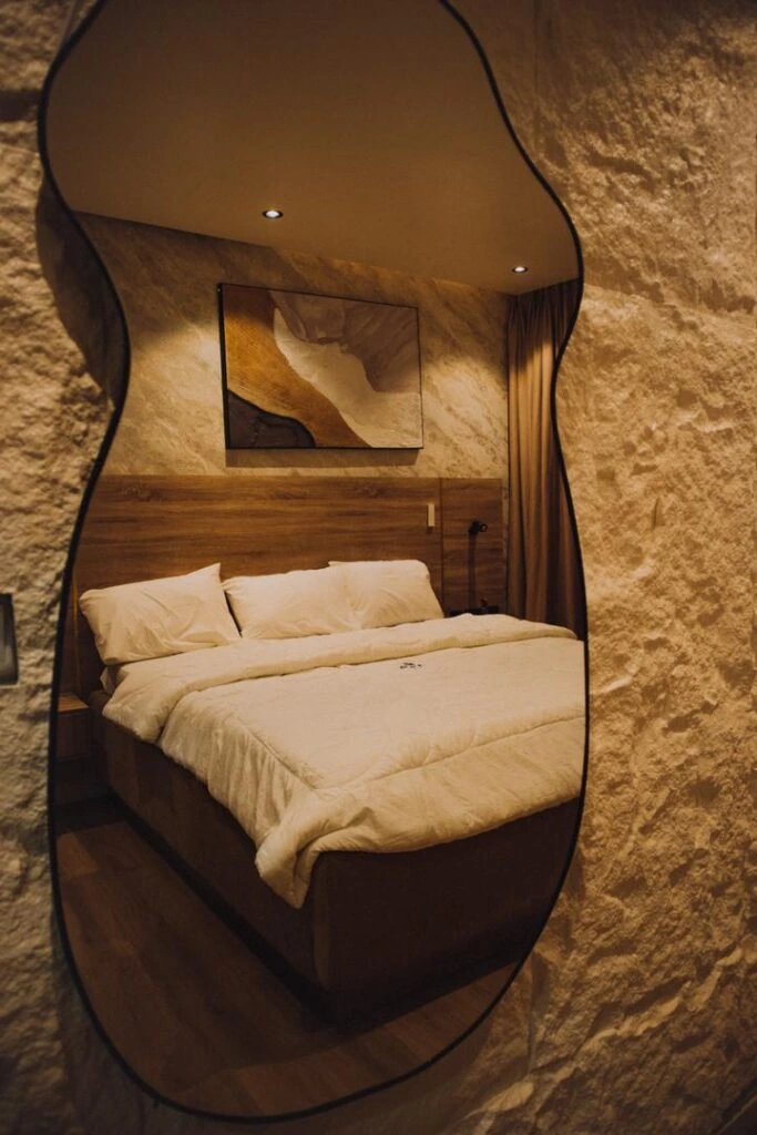 Elegant Amora Resort hotel room reflected in a sculptural mirror